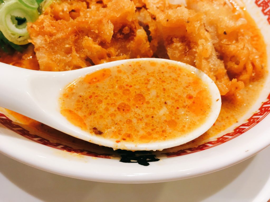 「肉汁麺ススム 下北沢店」の「肉汁パーコー担々麺」のスープの写真