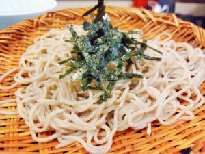 ザルに載ったそば。上には刻み海苔がかかっている。