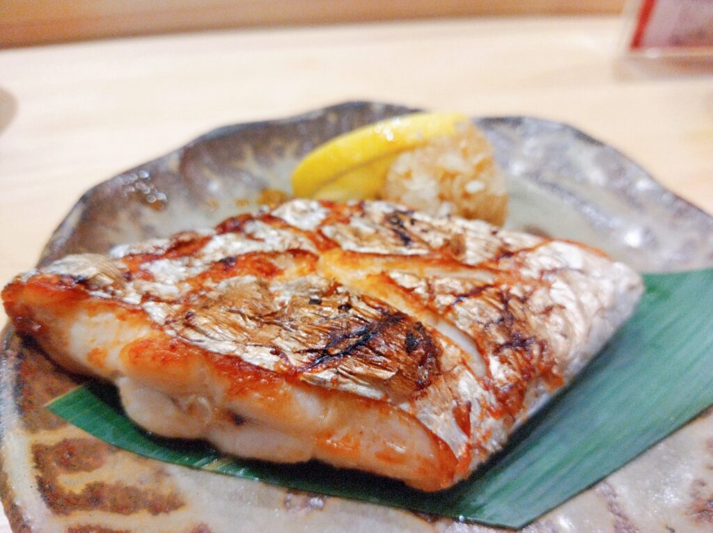 お皿に乗った太刀魚の塩焼きにレモンと大根おろしが添えられている