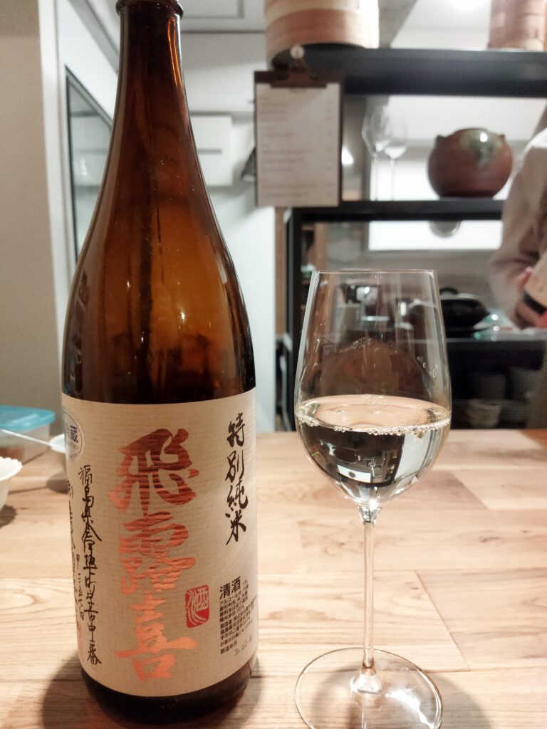 グラスに入った日本酒とボトルの写真