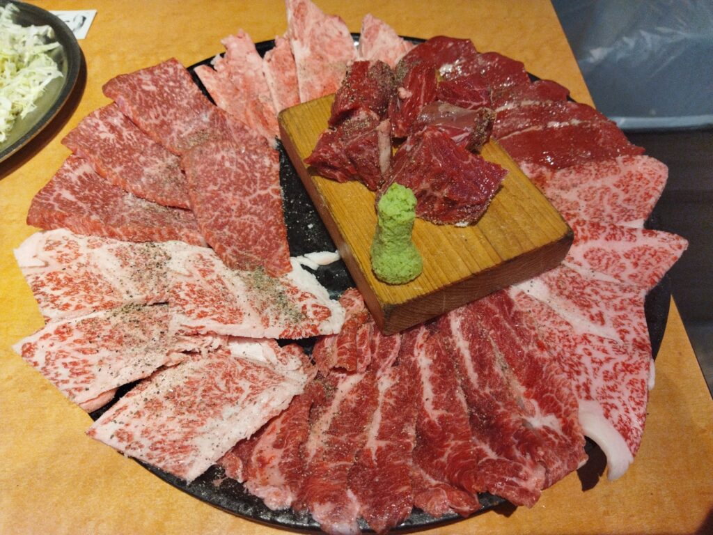 黒の大皿に7種類のお肉が隙間なく並べられている