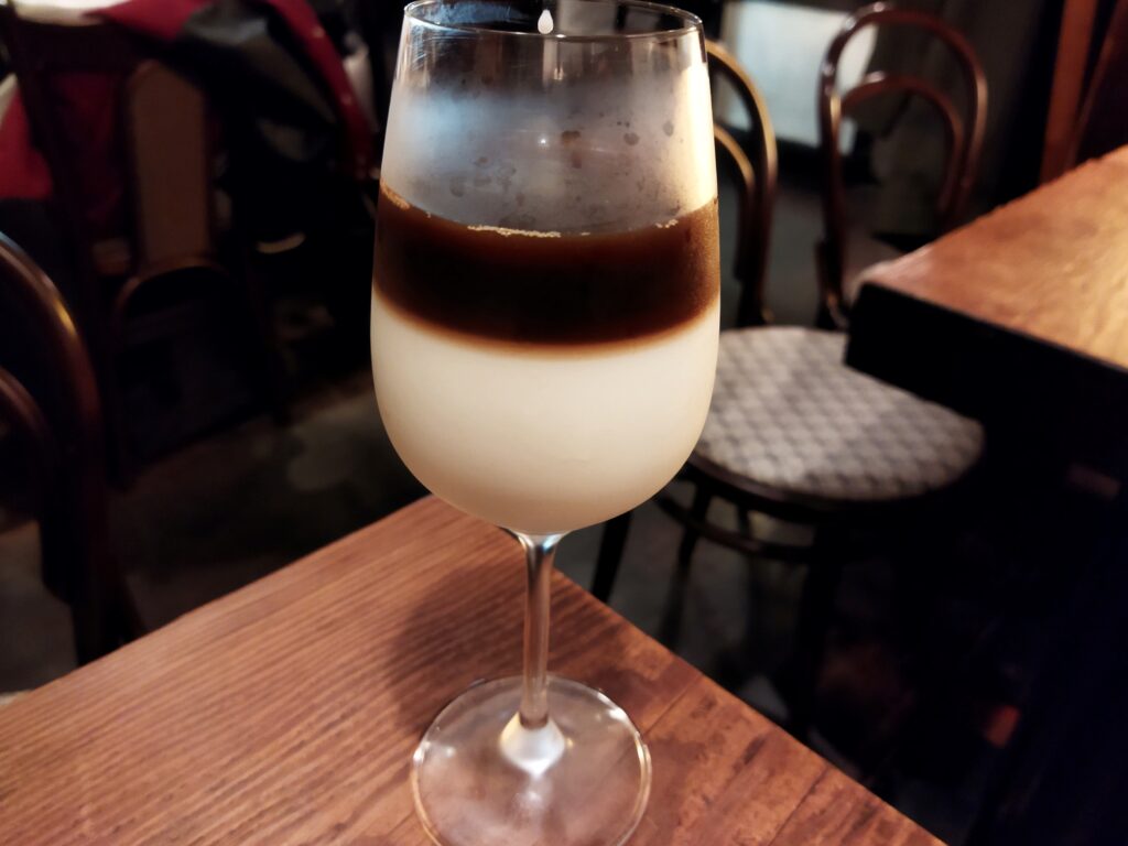 グラスに白と黒の二層で液体が入っている