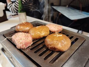 月島「焼肉 凛」の上タン塩としいたけを網で焼く様子